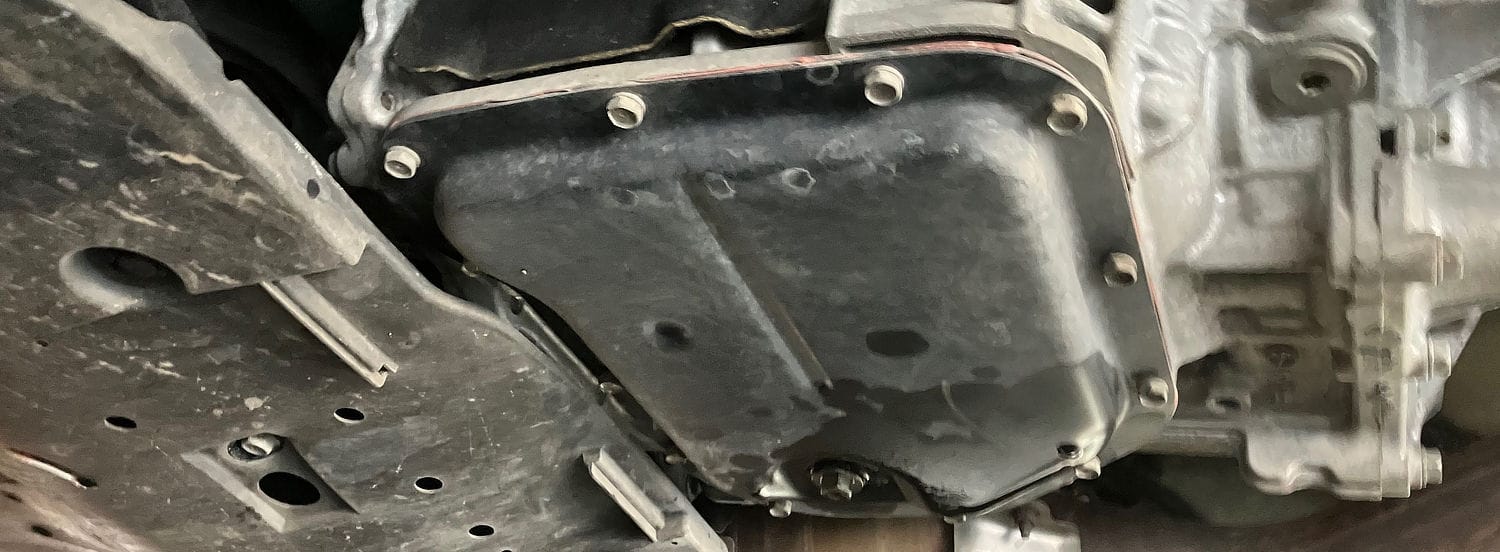 Subaru transmission pan and drain plug viewed from beneath the vehicle